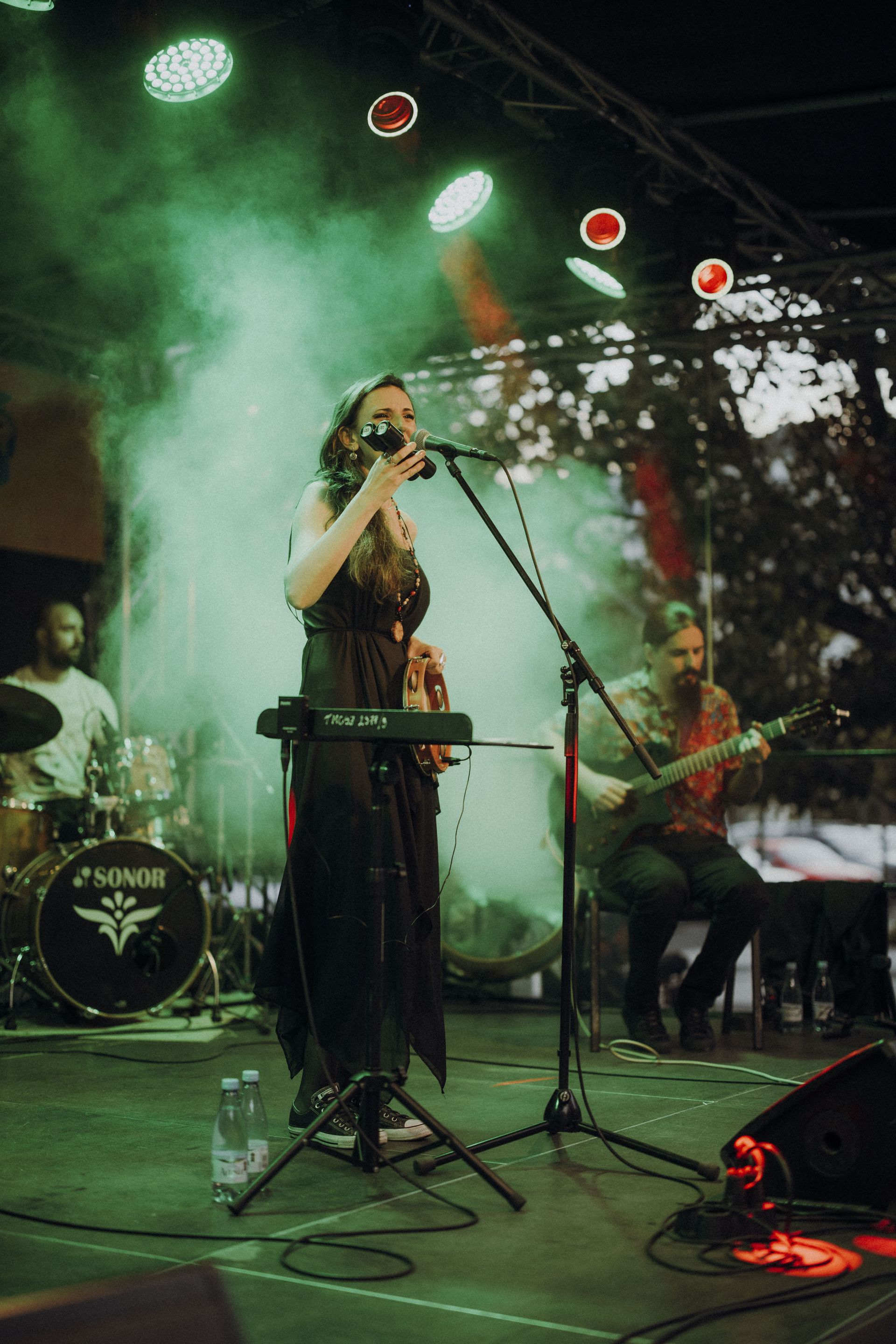 Mara Halunga performing under green stage lights